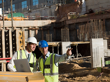 Two men utilizing IT Services for construction industry.
